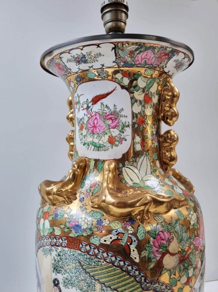 Close-up of the neck of a Chinese vase lamp featuring gilded raised Chilong dragons and Foo dog handles
