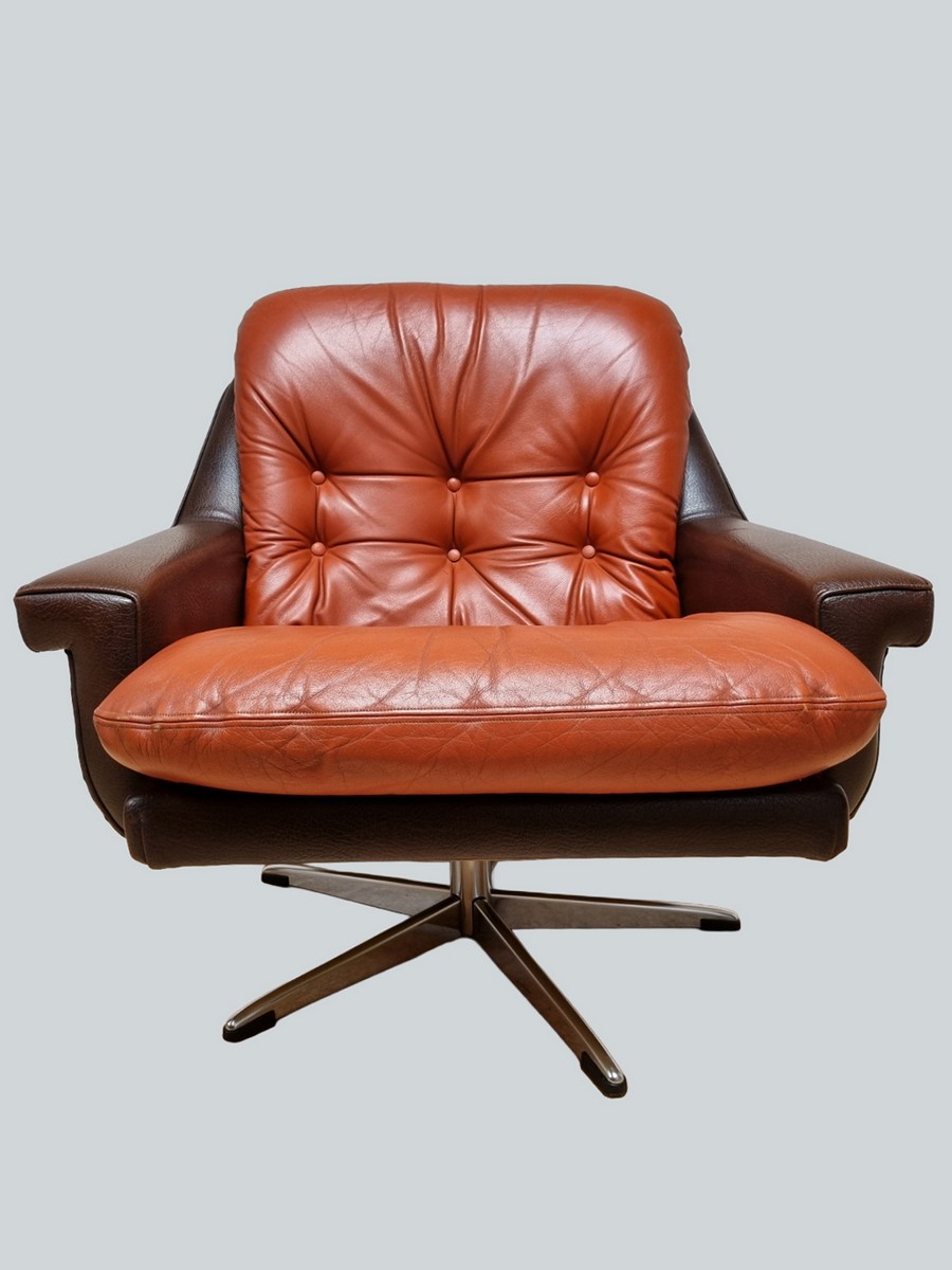 Great 70s swivel armchair with a brown faux leather shell and a caramel/orange leather cushion. Beautiful sturdy metal star base. Designer/manufacturer unknown, probably Scandinavian, but most importantly..... it is incredibly comfortable. The armchair i